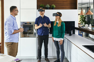 Couple wearing VR glasses shopping for a new kitchen in showroom - ZEDF02440