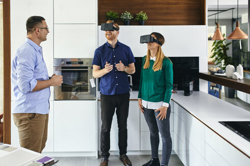 Paar mit VR-Brille beim Einkaufen für eine neue Küche im Ausstellungsraum - ZEDF02440