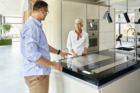 Mann und reife Frau unterhalten sich in einem Küchengeschäft - ZEDF02450