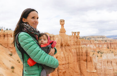 Frau trägt ihre Tochter in einer Babytrage bei den Hoodoos im Bryce Canyon, Utah, USA - GEMF02985