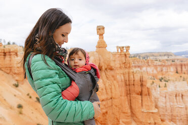 Frau trägt ihre Tochter in einer Babytrage bei den Hoodoos im Bryce Canyon, Utah, USA - GEMF02986