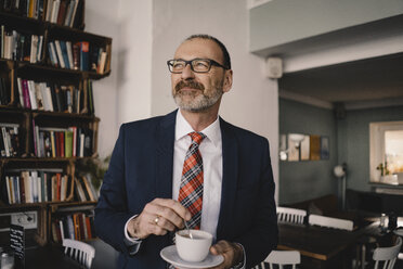 Älterer Geschäftsmann in einem Café mit einer Tasse Kaffee - KNSF05934