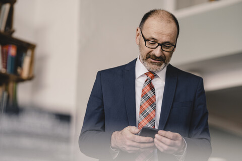 Mature businessman using cell phone in a cafe stock photo