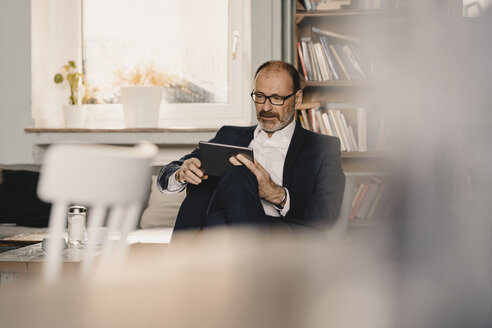 Älterer Geschäftsmann benutzt Tablet in einem Cafe - KNSF05939