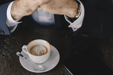 Nahaufnahme eines Geschäftsmannes mit Tablet und Cappuccino in einem Cafe - KNSF05958