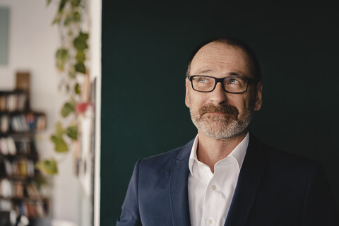 Portrait of smiling mature businessman looking up stock photo