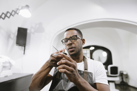 Porträt eines Friseurs mit Schere in einem Friseursalon, lizenzfreies Stockfoto