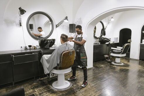 Friseur, der einem Kunden im Friseursalon die Haare schneidet - AHSF00507