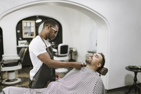 Barbier schneidet Bart eines Kunden im Friseursalon - AHSF00511