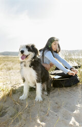 Junge Frau mit Hund und Gitarre am Strand - MGOF04067