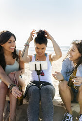 Glückliche Freundinnen mit Bierflaschen machen ein Selfie am Strand - MGOF04077