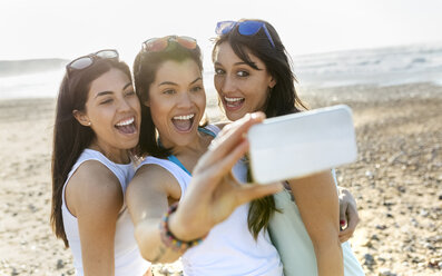 Porträt von glücklichen Freundinnen, die ein Selfie am Strand machen - MGOF04107
