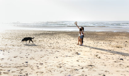 Drei Frauen mit Hund beim Spaziergang am Strand - MGOF04109