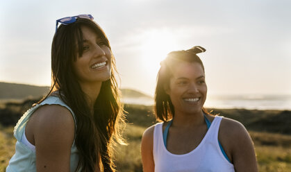 Porträt von zwei glücklichen Freundinnen in den Dünen bei Sonnenuntergang - MGOF04118