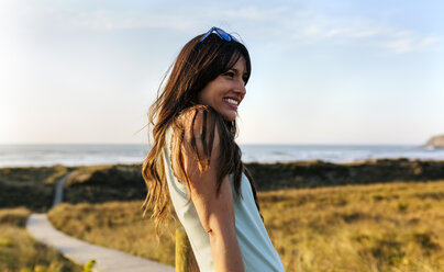 Portrait of a smiling woman in dunes at sunset - MGOF04120