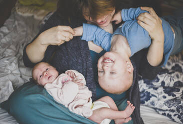 Mother playing with a toddler son and a newborn daughter - IHF00092