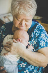 Grandmother holding her sleeping baby granddaughter - IHF00096