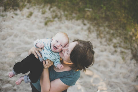 Happy mother holding her baby girl outdoors stock photo