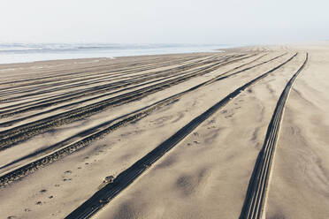 Tire tracks on the soft surface of sand on a beach. - MINF11410