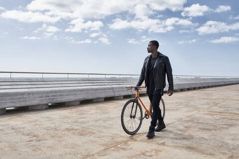 Mann mit Fahrrad auf der Uferpromenade, lizenzfreies Stockfoto