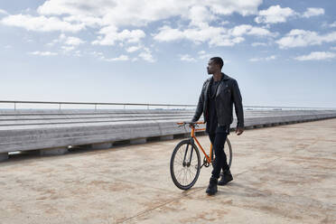 Mann mit Fahrrad auf der Uferpromenade - JND00045