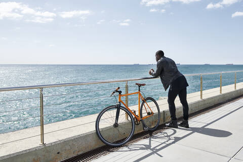 Man with bike on waterfront promenade stock photo