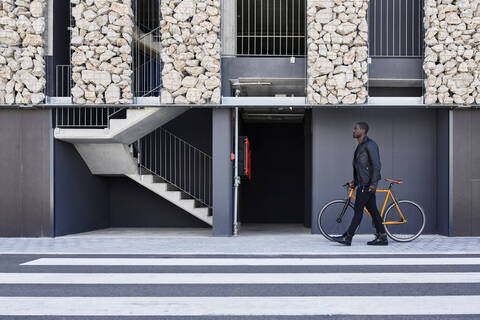 Mann mit Fahrrad auf dem Bürgersteig, lizenzfreies Stockfoto