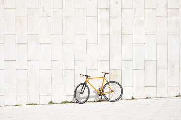Bicycle leaning on concrete wall - JND00081