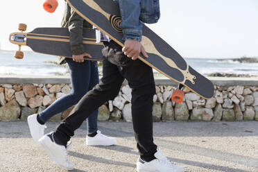 Junges Paar mit Longboards auf der Promenade, Teilansicht - JPTF00128