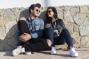 Young couple in love sitting side by side on longboard - JPTF00129