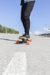 Young man standing on longboard, partial view - JPTF00134