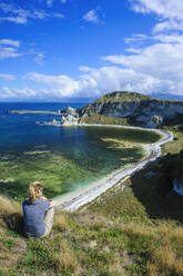 Tourist looking from the cliff top over the Kaikoura Peninsula, South island, New Zealand - RUNF02590