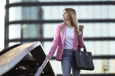 Junge Geschäftsfrau mit Smartphone und Coffee to go in der Hand - JSRF00192