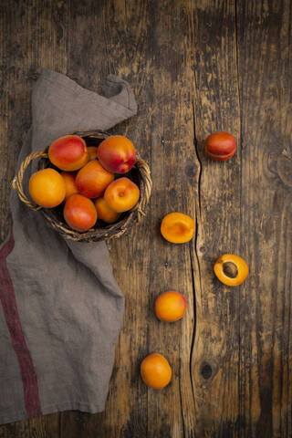 Aprikosen im Korb auf dunklem Holz, lizenzfreies Stockfoto
