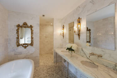 Bathtub and mirrors in ornate bathroom - MINF11715