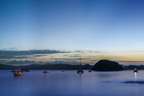 Boote in der Bucht in der Morgendämmerung, Bay of Islands, Neuseeland, lizenzfreies Stockfoto