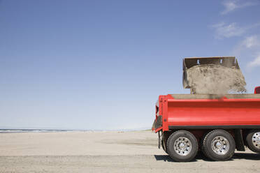 Lastwagen schaufelt Sand am Strand - MINF11930