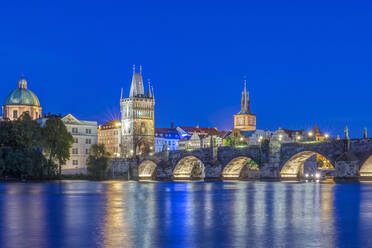 Karlsbrücke und beleuchtete Stadt in der Abenddämmerung, Prag, Tschechische Republik - MINF12124