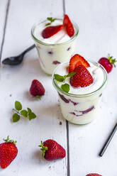 Joghurt mit frischen Erdbeeren und Minze auf Holz - SARF04302