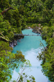 Schwenkbare Brücke über dem türkisfarbenen Wasser in der Hokitika-Schlucht, Südinsel, Neuseeland - RUNF02649