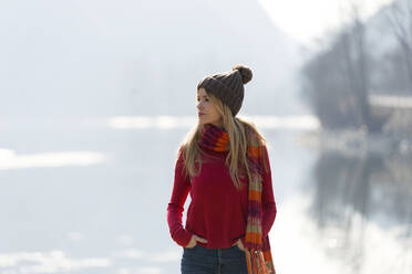 Junge blonde Frau an einem See im Winter - JSRF00205
