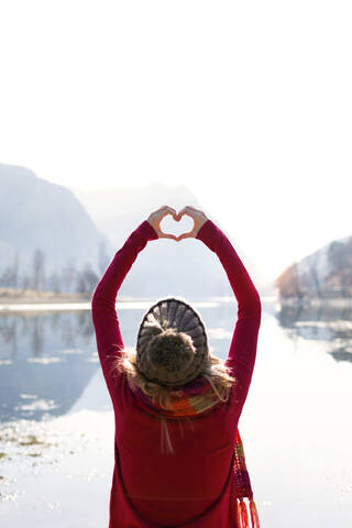 Portrait of young woman making heart shape with hands and fingers stock photo