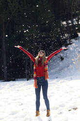 Junge blonde Frau wirft Schnee im Winter - JSRF00225