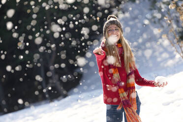 Junge blonde Frau wirft mit Schnee im Winter - JSRF00226