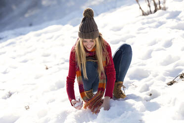 Junge blonde Frau spielt mit Schnee im Winter - JSRF00227