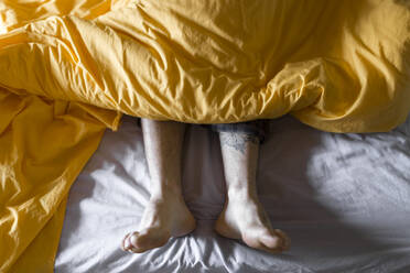 Tattooed man lying in bed - JPTF00142