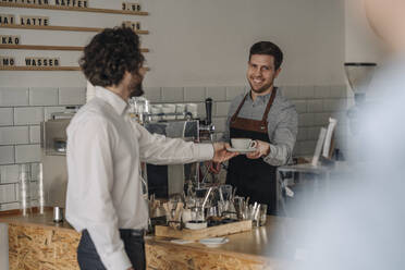 Barista bereitet Kaffee für einen Kunden zu - KNSF05978