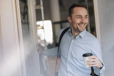 Geschäftsmann verlässt den Kaffeeautomaten mit Kaffee zum Mitnehmen - KNSF06004