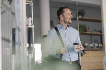 Geschäftsmann verlässt den Kaffeeautomaten mit Kaffee zum Mitnehmen - KNSF06005