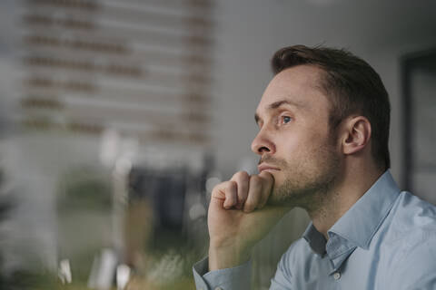 Erfolgreicher Geschäftsmann sitzt in einem Café und denkt nach, lizenzfreies Stockfoto